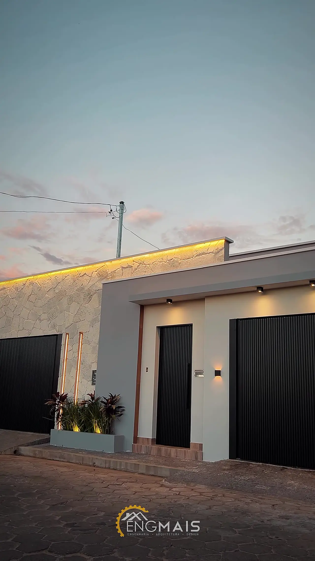 Fachada entregue com porta pivotante preta e iluminação